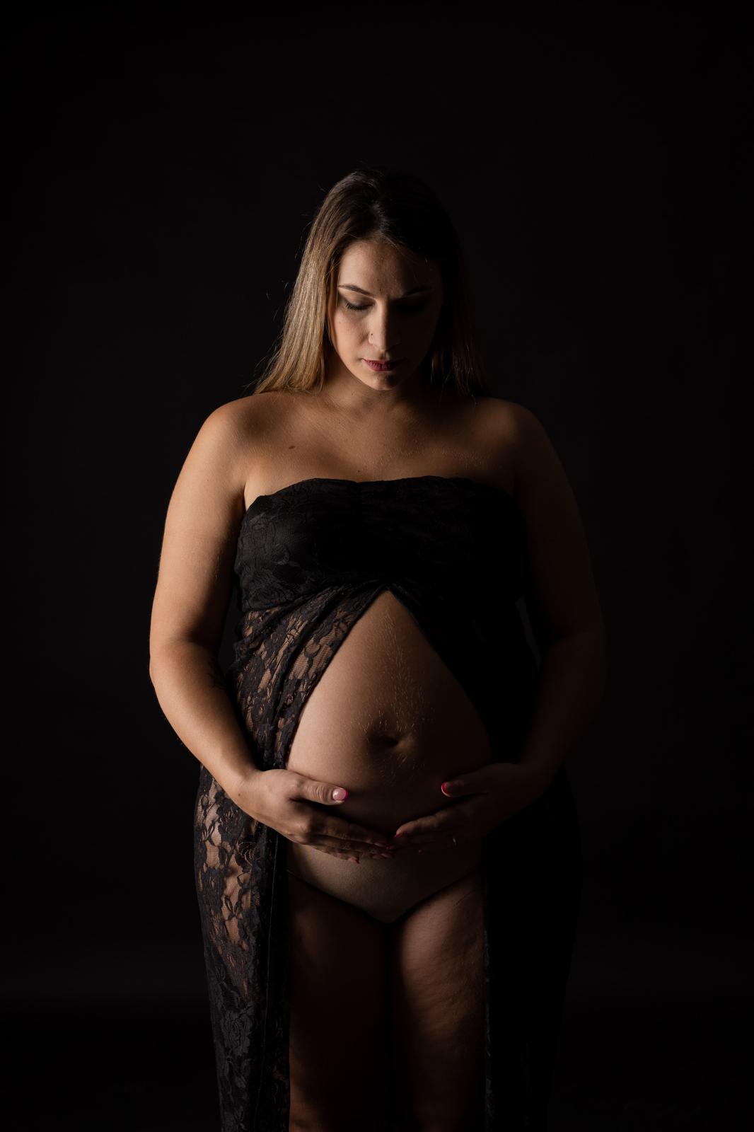 Futura mamma con tessuto in pizzo nero, sguardo sul pancione