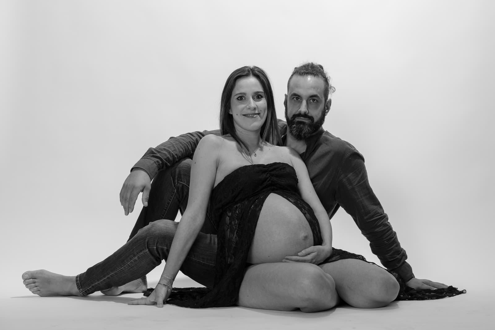 Coppia seduta a terra su fondo chiaro