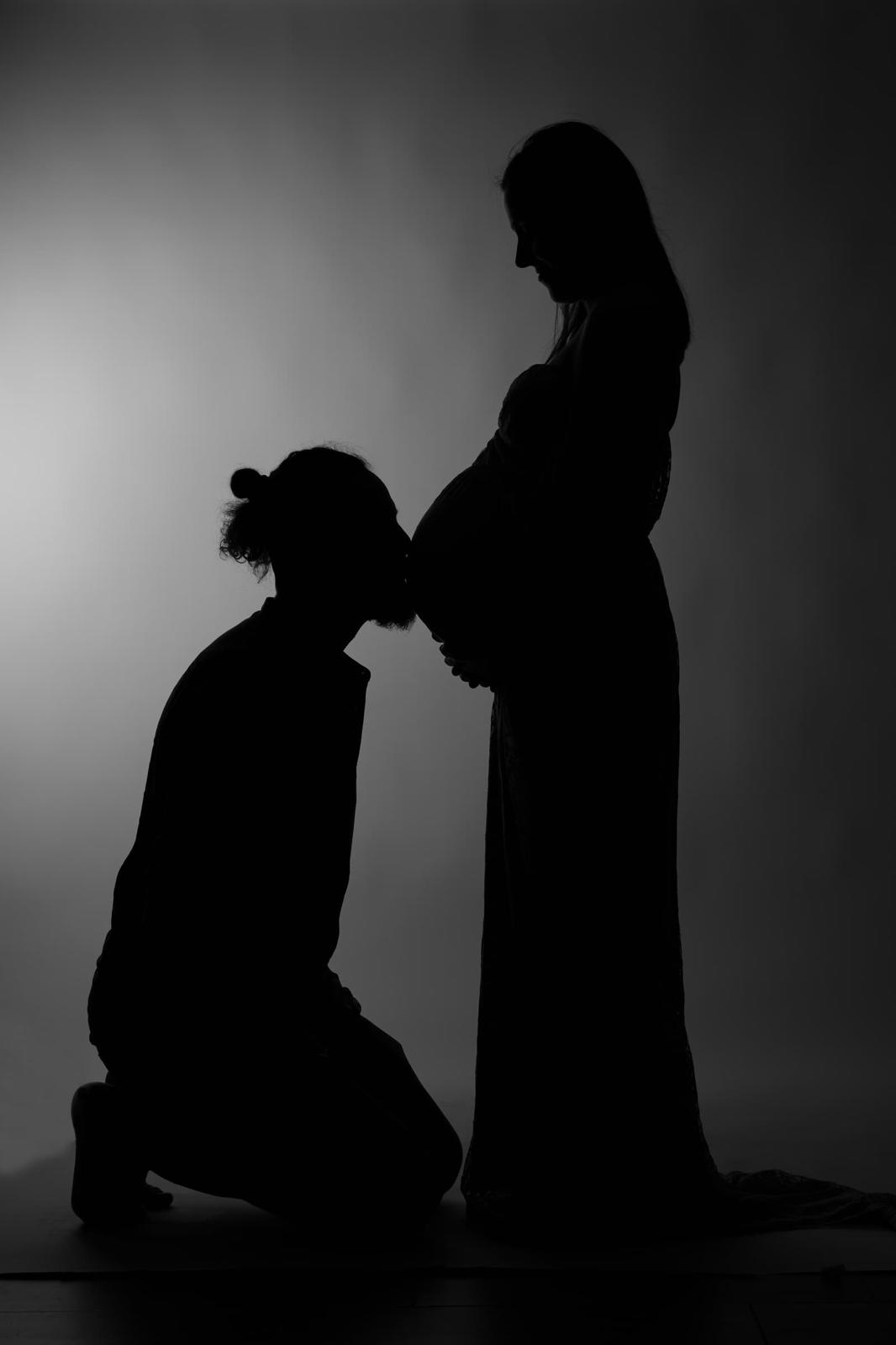 Silhouette di un papà che bacia il pancione