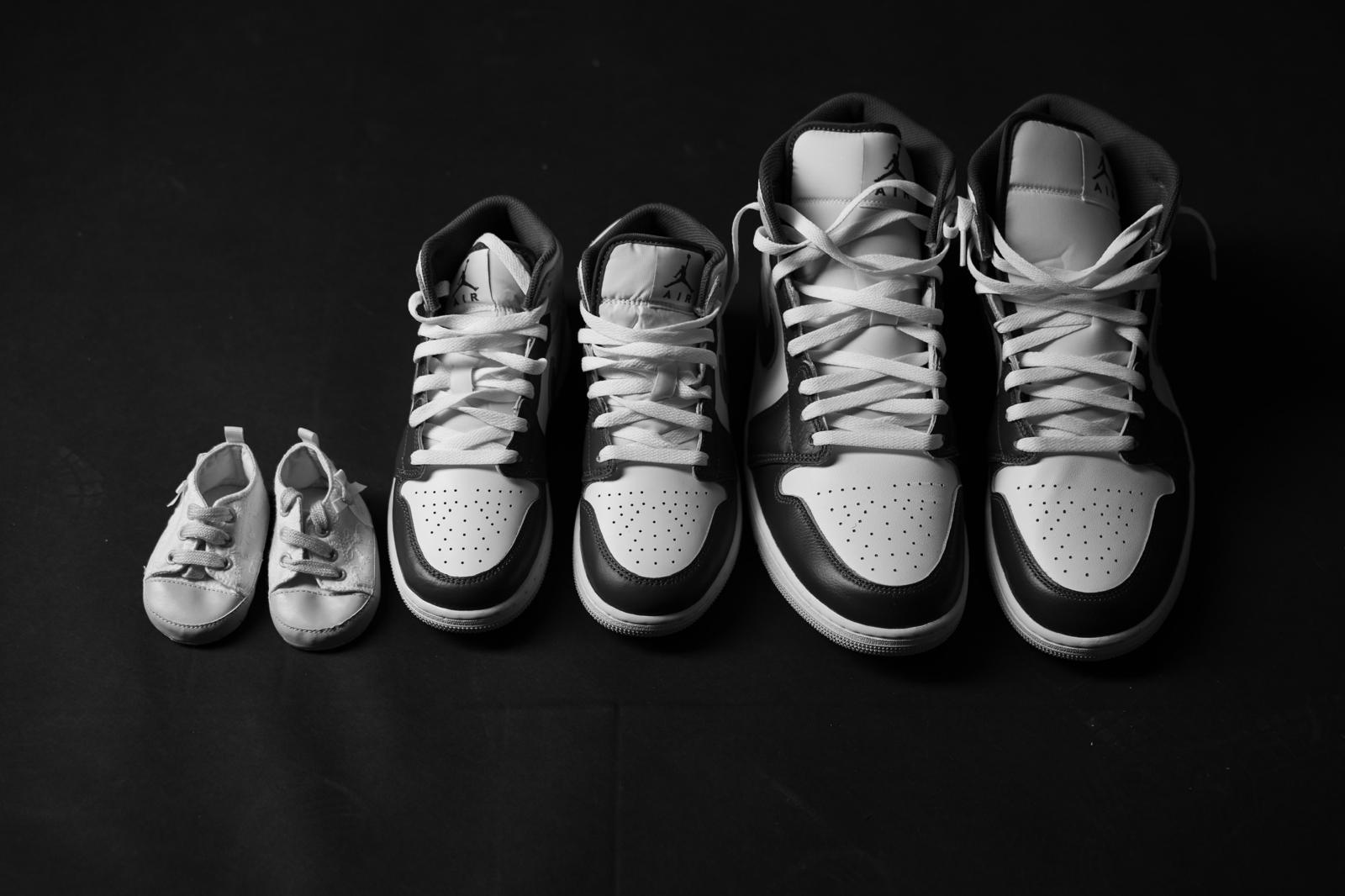 Scarpine del bebè accanto alle sneakers dei genitori